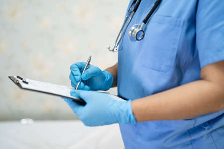 Asian doctor wearing face shield and PPE suit new normal to check patient protect safety infection...