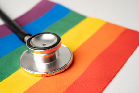 Black stethoscope on rainbow flag background, symbol of LGBT pride month celebrate annual in June social, symbol of gay, lesbian, bisexual, transgender, human rights and peace.の写真素材
