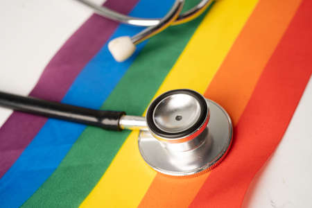 Black stethoscope on rainbow flag background, symbol of LGBT pride month celebrate annual in June social, symbol of gay, lesbian, bisexual, transgender, human rights and peace.の写真素材