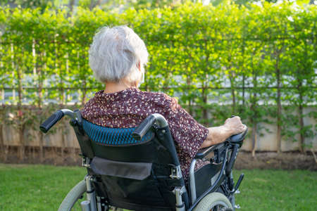 Asian senior woman patient on electronic wheelchair in park.の写真素材