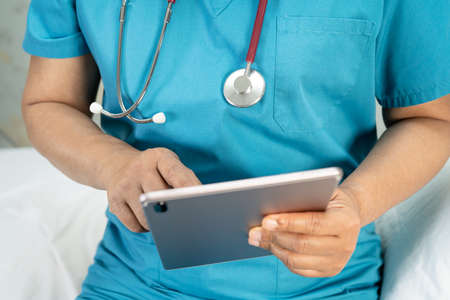 Doctor holding digital tablet to search data for treat patient in nursing hospital ward : healthy...