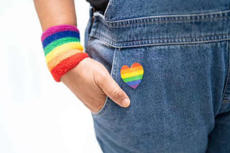 Asian lady wearing rainbow flag wristbands, symbol of LGBT pride month celebrate annual in June...
