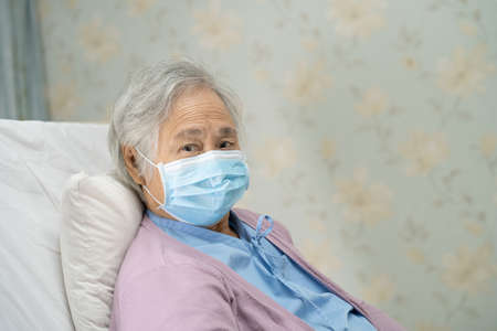 Asian senior or elderly old lady woman patient wearing a face mask new normal in hospital for protect safety infection Covid-19 Coronavirus.の写真素材
