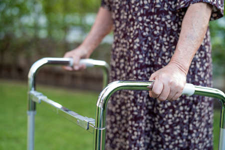 Asian senior or elderly old lady woman patient walk with walker in park,  healthy strong medical concept.の写真素材