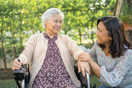 Help and care Asian senior or elderly old lady woman patient sitting on wheelchair at park in nursing hospital ward, healthy strong medical concept.の写真素材