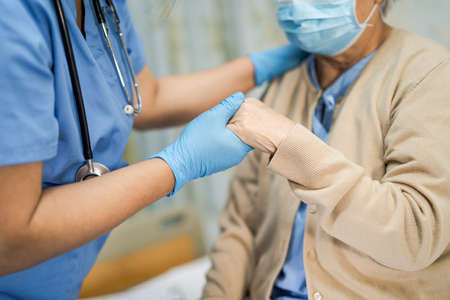 Asian senior or elderly old lady woman patient wearing a face mask new normal in hospital for protect safety infectionの写真素材