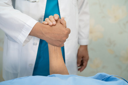 Holding hands Asian senior or elderly old lady woman patient with love, care, encourage and empathy at nursing hospital ward, healthy strong medical conceptの写真素材