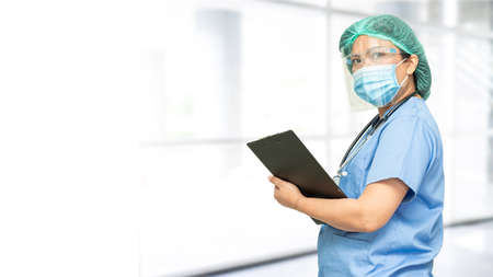 Asian doctor wearing face shield and PPE suit to check patient protect safety infection  outbreak at...
