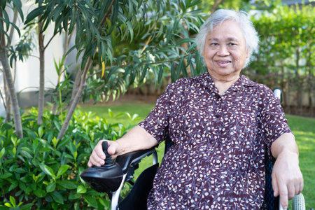 Asian senior or elderly old lady woman patient on electric wheelchair with remote control at nursing hospital ward, healthy strong medical conceptの写真素材