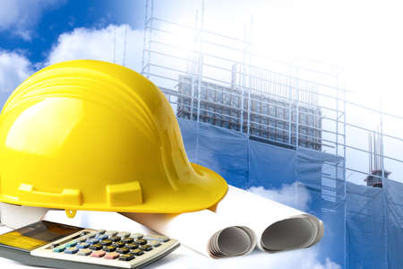 Construction helmet and calculator for engineering work project at site.の写真素材