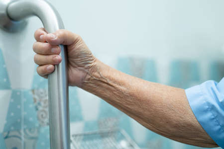 Asian senior or elderly old lady woman patient use slope walkway handle security with help support...