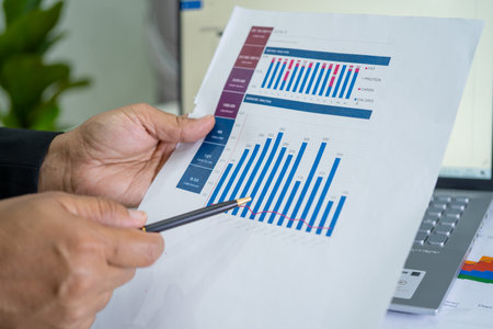 Asian accountant working and analyzing financial reports project accounting with chart graph and calculator in modern office, finance and business concept.の写真素材
