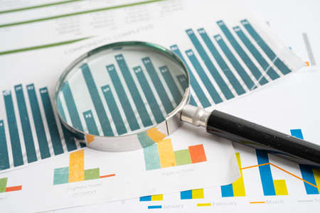 Magnifying glass on charts graphs paper. Financial development, Banking Account, Statistics,...