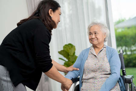Help and care Asian senior or elderly old lady woman patient sitting on wheelchair at nursing hospital ward, healthy strong medical conceptの写真素材