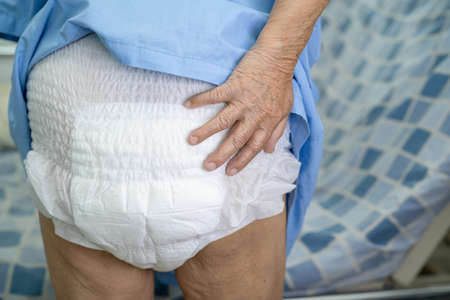 Asian senior or elderly old lady woman patient wearing incontinence diaper in nursing hospital ward,...