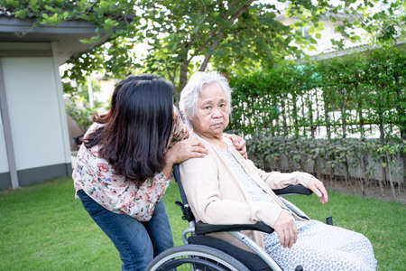 Help Asian senior or elderly old lady woman on electric wheelchair and wearing a face mask for...