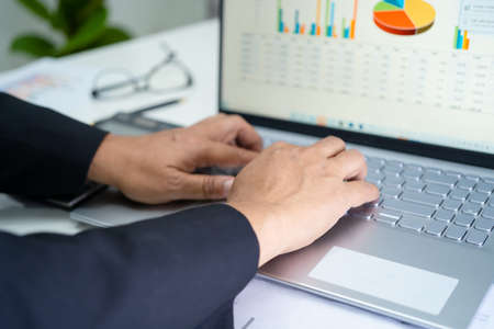 Asian accountant working and analyzing financial reports project accounting with chart graph in modern office, finance and business concept.の写真素材