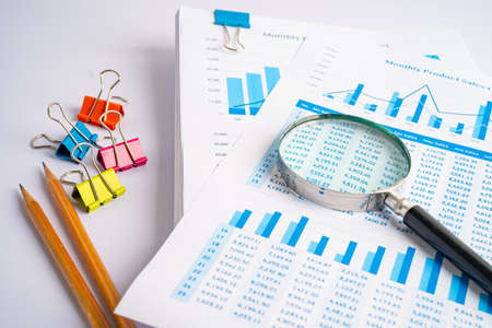 Magnifying glass on charts graphs paper. Financial development, Banking Account, Statistics, Investment Analytic research data economy, Stock exchange trading, Business office company meeting concept.の写真素材