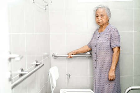 Asian senior or elderly old lady woman patient use toilet bathroom handle security in nursing hospital ward, healthy strong medical concept.の写真素材