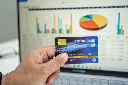 Asian accountant working, calculate and analyzing report project accounting with notebook and credit...