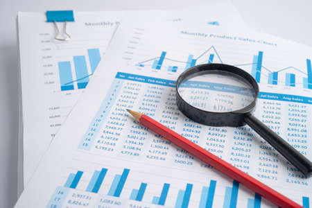 Magnifying glass on charts graphs paper. Financial development, Banking Account, Statistics,...