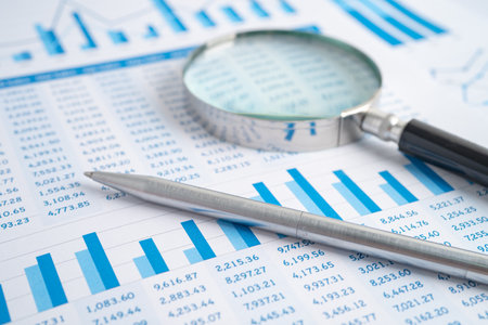 Magnifying glass on charts graphs paper. Financial development, Banking Account, Statistics,...