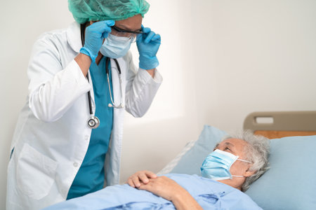 Doctor help Asian senior or elderly old lady woman patient wearing a face mask in hospital.の写真素材