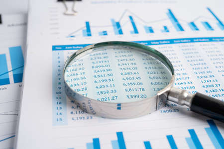 Magnifying glass on charts graphs paper. Financial development, Banking Account, Statistics,...