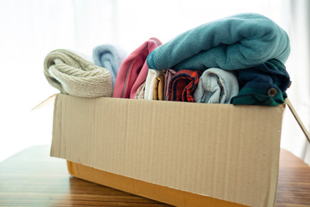Donation box with used clothes at home to support help for poor people in the world.