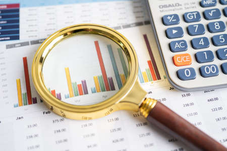 Magnifying glass on charts graphs paper. Financial development, Banking Account, Statistics,...