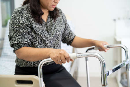 Asian lady patient pain her back wrist orthopedic lumbar with walker.