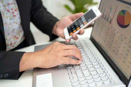 Asian accountant working and analyzing financial reports project accounting with chart graph and...