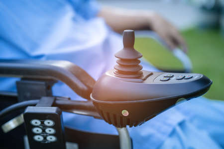Asian senior or elderly old lady woman patient on electric wheelchair with remote control at nursing hospital ward, healthy strong medical conceptの写真素材