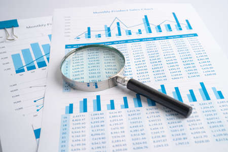 Magnifying glass on charts graphs paper. Financial development, Banking Account, Statistics,...