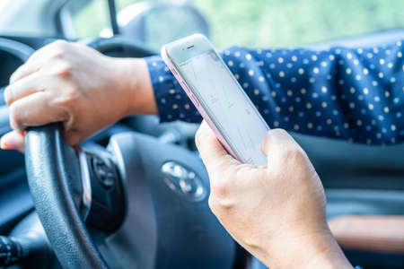Bangkok, Thailand, July 1, 2021 Holding iPhone in toyota sienta car to communication with family and...