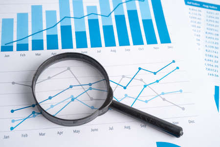 Magnifying glass on charts graphs paper. Financial development, Banking Account, Statistics, Investment Analytic research data economy, Stock exchange trading, Business office company meeting concept.の写真素材