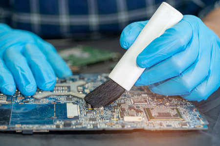 Technician use brush and air blower ball to clean dust in circuit board computer. Repair upgrade and...
