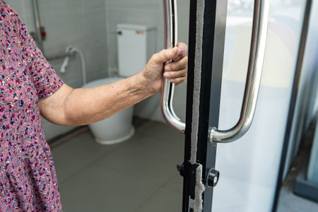 Asian senior or elderly old lady woman patient use toilet bathroom handle security in nursing hospital ward, healthy strong medical concept.の写真素材
