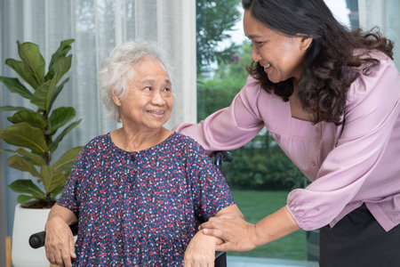 Help Asian senior or elderly old lady woman sitting on wheelchair and wearing a face mask for protect safety infection Covid 19 Coronavirus.の写真素材