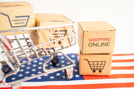 Box with shopping online cart logo and USA America flag, Import Export Shopping online or commerce finance delivery service store product shipping, trade, supplier concept.の写真素材