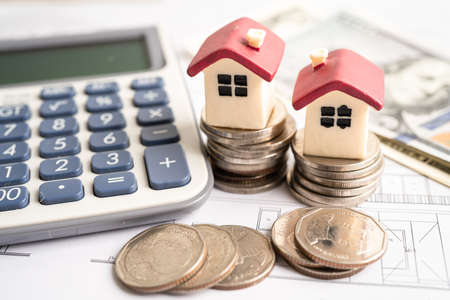 House with stack coins and uS dollar money on plan house, mortgage home loan finance concept.