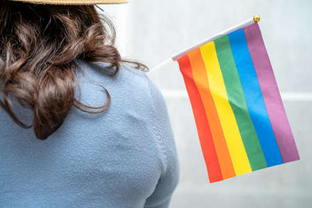 Asian lady with rainbow flag heart, symbol of LGBT pride month celebrate annual in June social of gay, lesbian, bisexual, transgender, human rights.の写真素材
