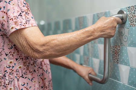 Asian senior or elderly old lady woman patient use toilet bathroom handle security in nursing hospital ward, healthy strong medical concept.の写真素材