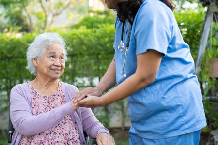 Doctor help and care Asian senior or elderly old lady woman patient sitting on wheelchair at nursing...