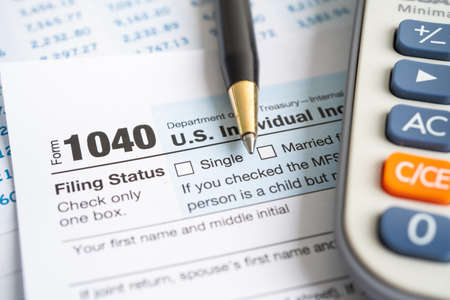 Tax Return form 1040 with USA America flag and dollar banknote, U.S. Individual Income.の写真素材