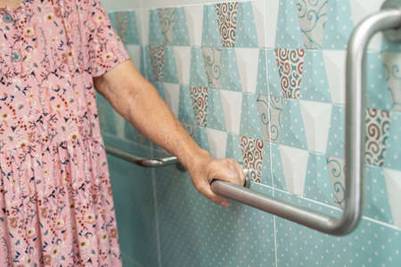 Asian senior or elderly old lady woman patient use toilet bathroom handle security in nursing hospital ward, healthy strong medical concept.の写真素材