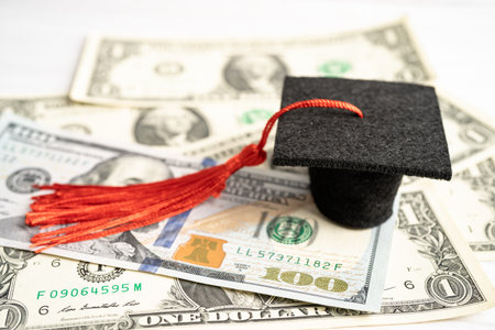 Graduation gap hat on US dollar banknotes money, Education study fee learning teach concept.の写真素材