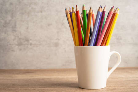 Colorful pencils in white cup with copy space, learning university education concept.の写真素材