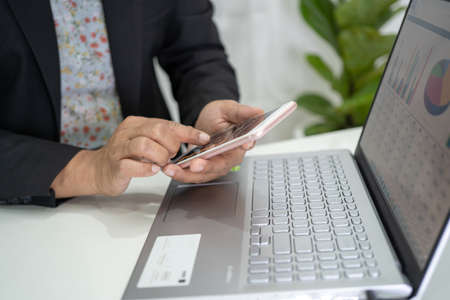 Asian accountant working and analyzing financial reports project accounting with chart graph and...