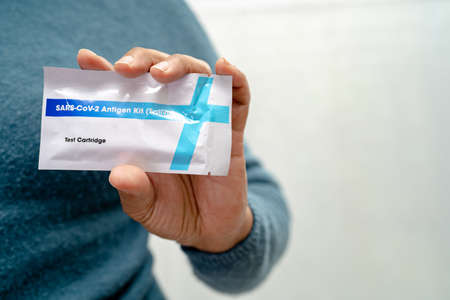 Asian doctor in PPE suit show positive test result with Saliva Antigen Test Kit for check Covid19 coronavirus in hospital.の写真素材